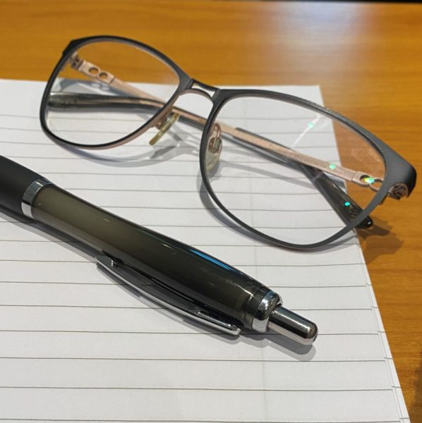 Bilde av skriveblokk, penn og briller