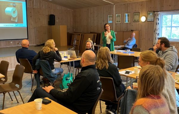 en gjeng mennesker sitter rundt flere bord 