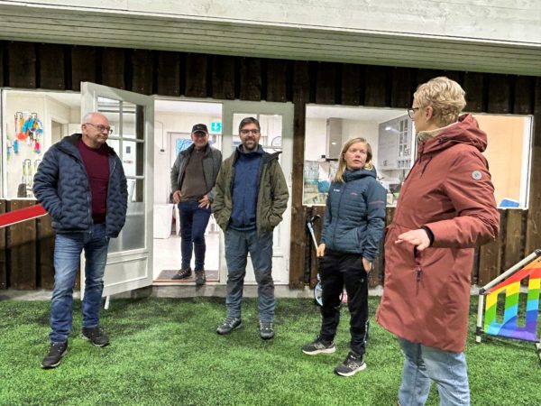 Mange mennesker står i ring og prater