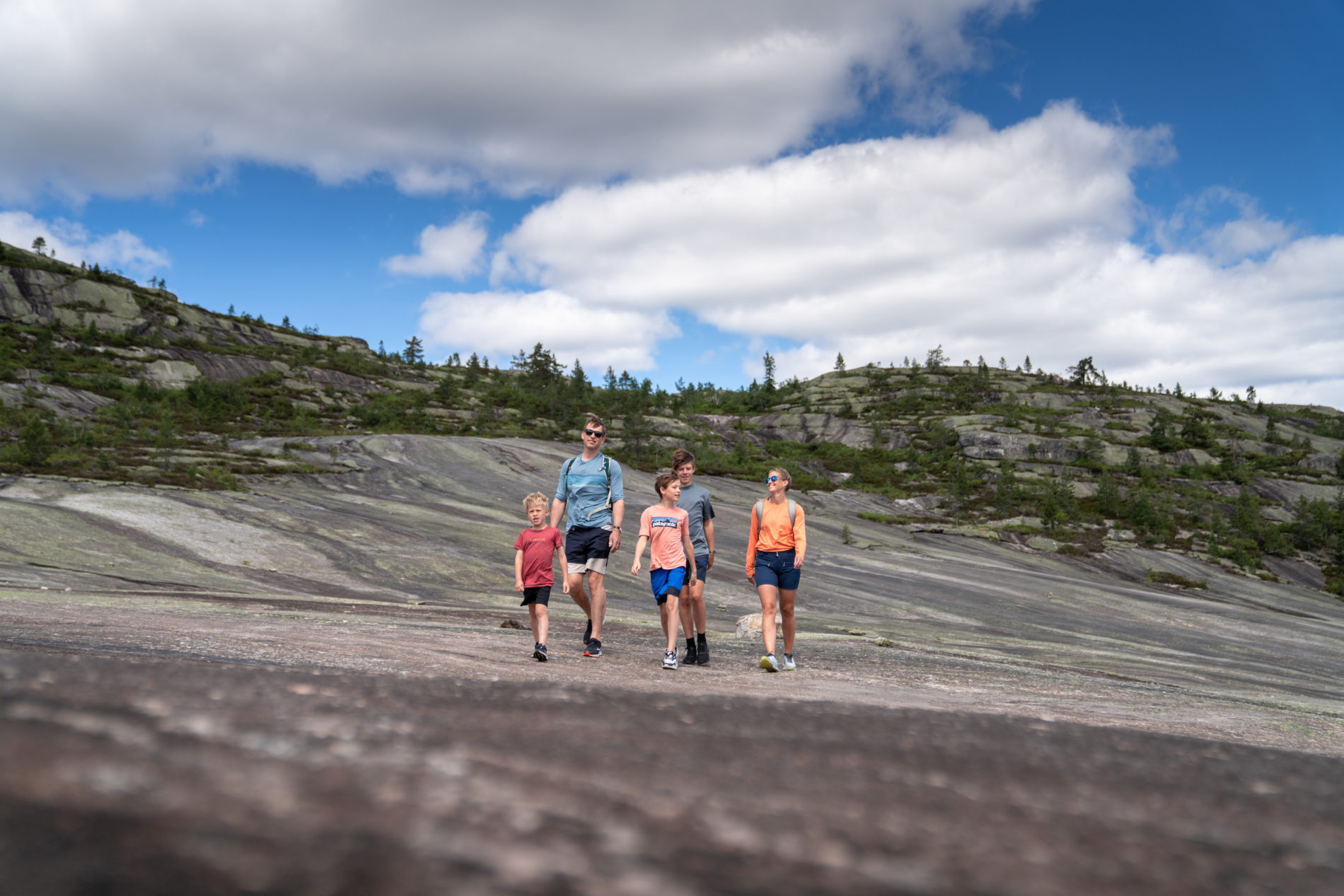 Familie med to voksne og to barn vandrer i fjellandskapet Himmerike på Gautefall